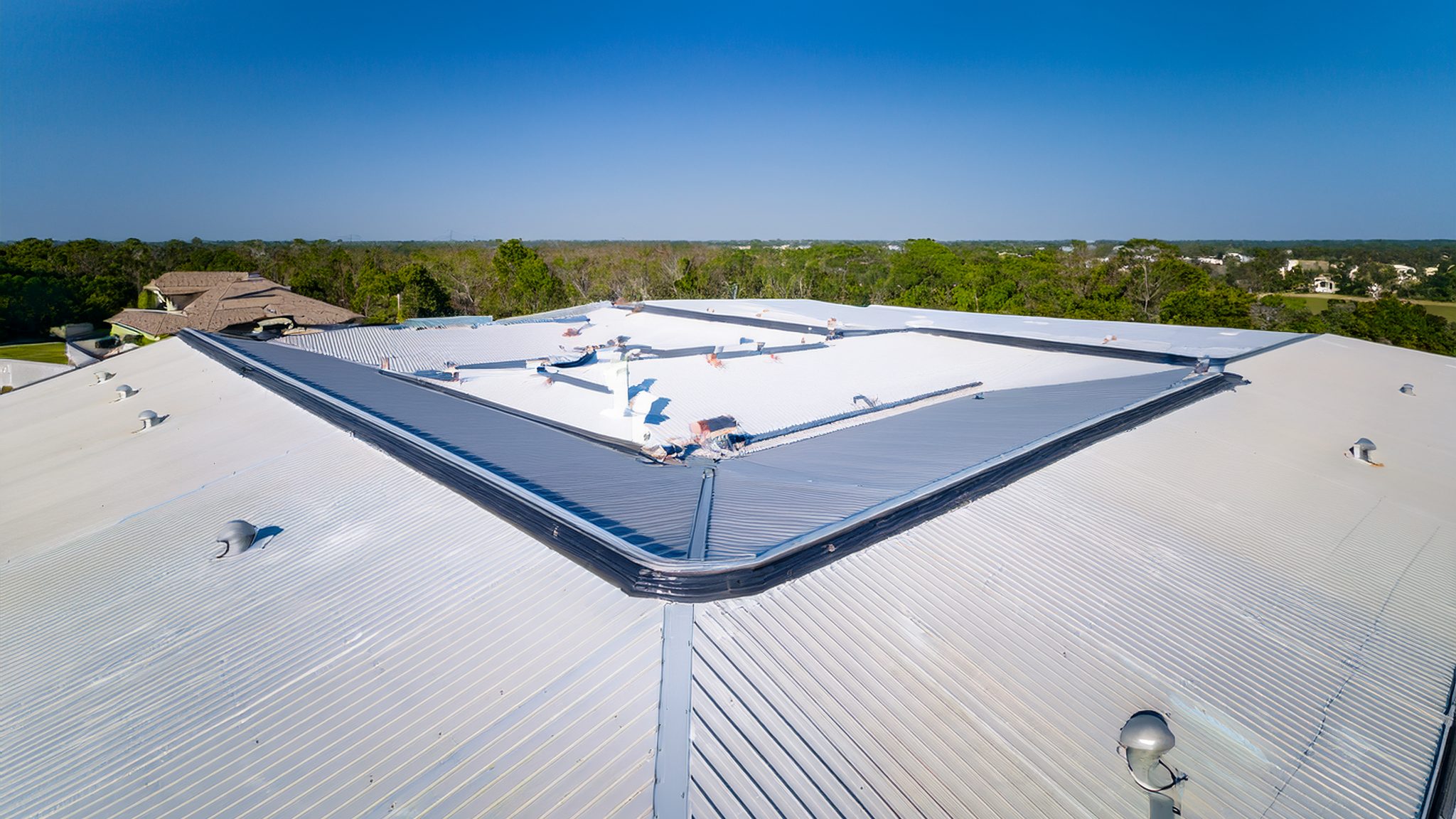 Aerial view of a white single-ply TPO membrane roof on a commercial building