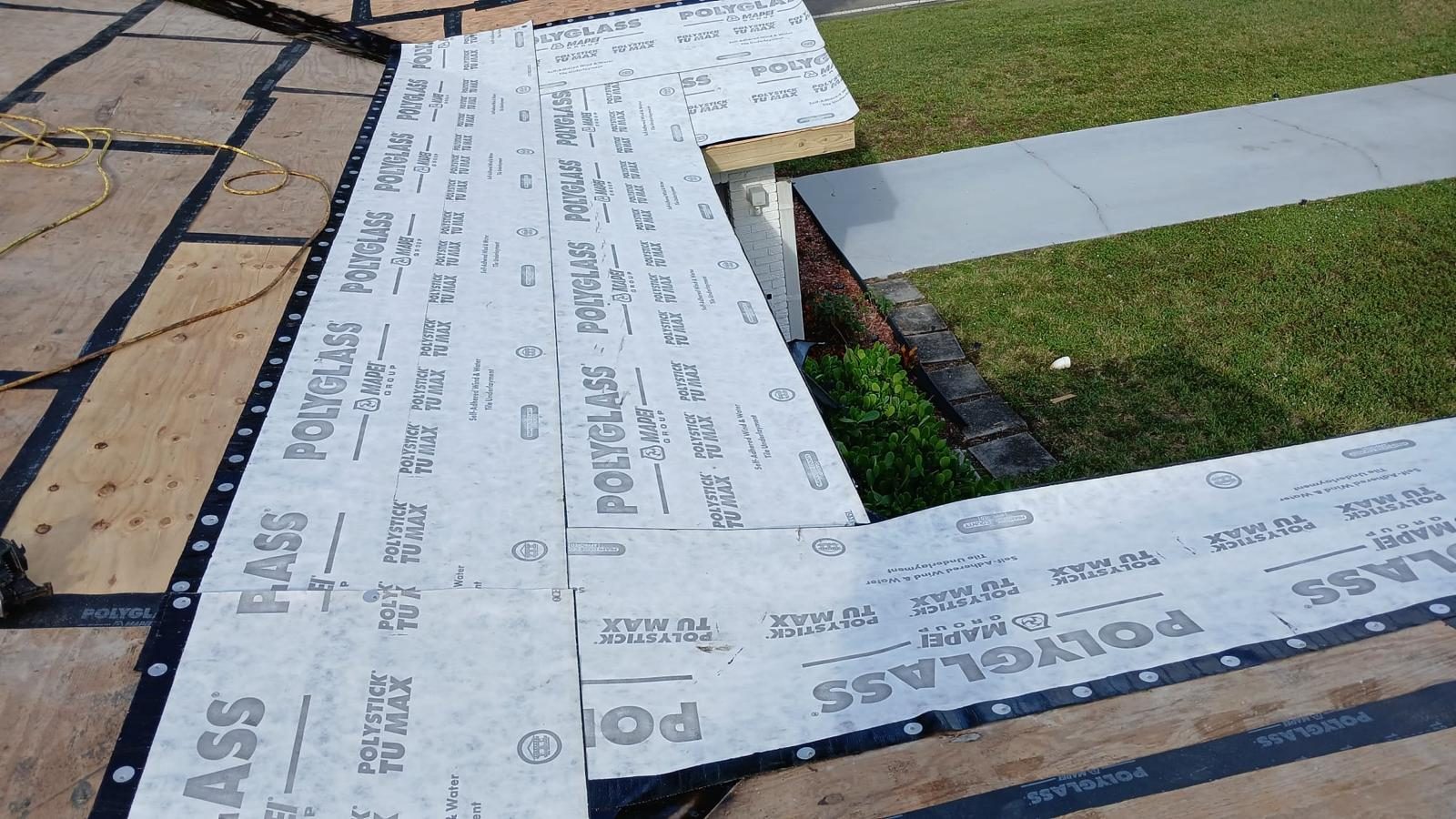 Rows of self-adhered underlayment rolled out over new roof decking